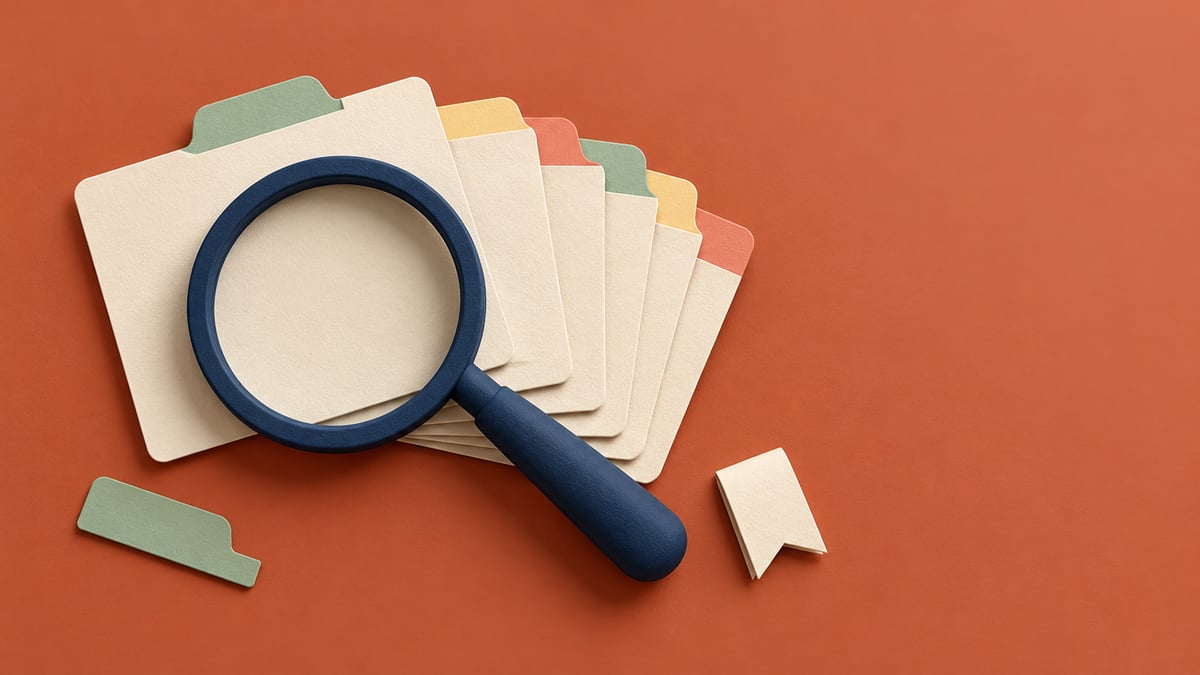 Conceptual navy magnifier over fanned cream index cards with pastel tabs on terracotta.